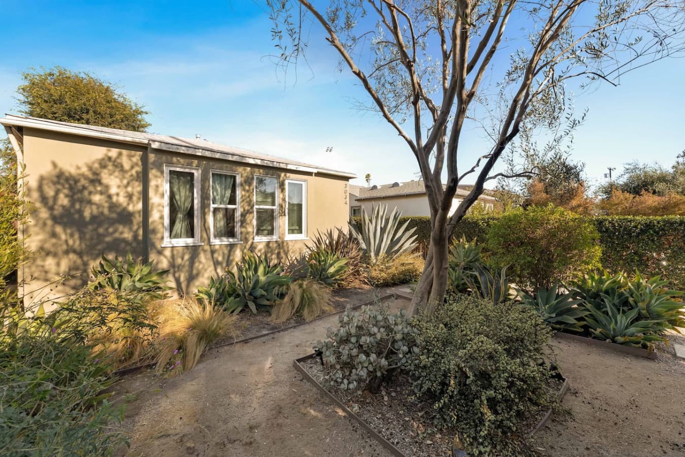 Charming exterior with native landscaping and a peaceful residential feel.