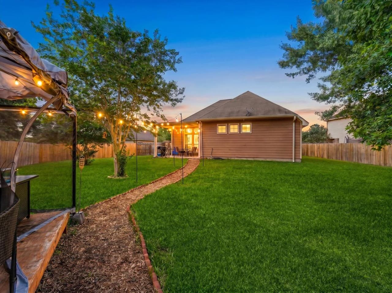Peaceful backyard pathway leading to a relaxing outdoor seating area perfect for evenings outside.