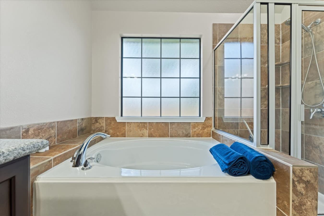 Relaxing soaking tub positioned beside large windows for a spa like experience.