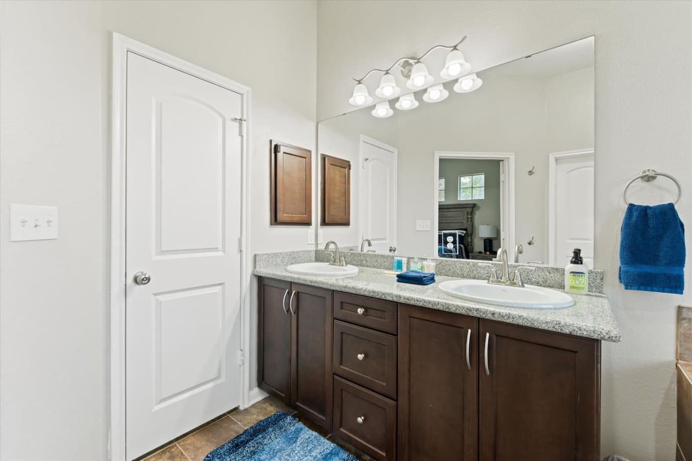 Spacious bathroom with dual sinks, granite countertops, and plenty of storage space.