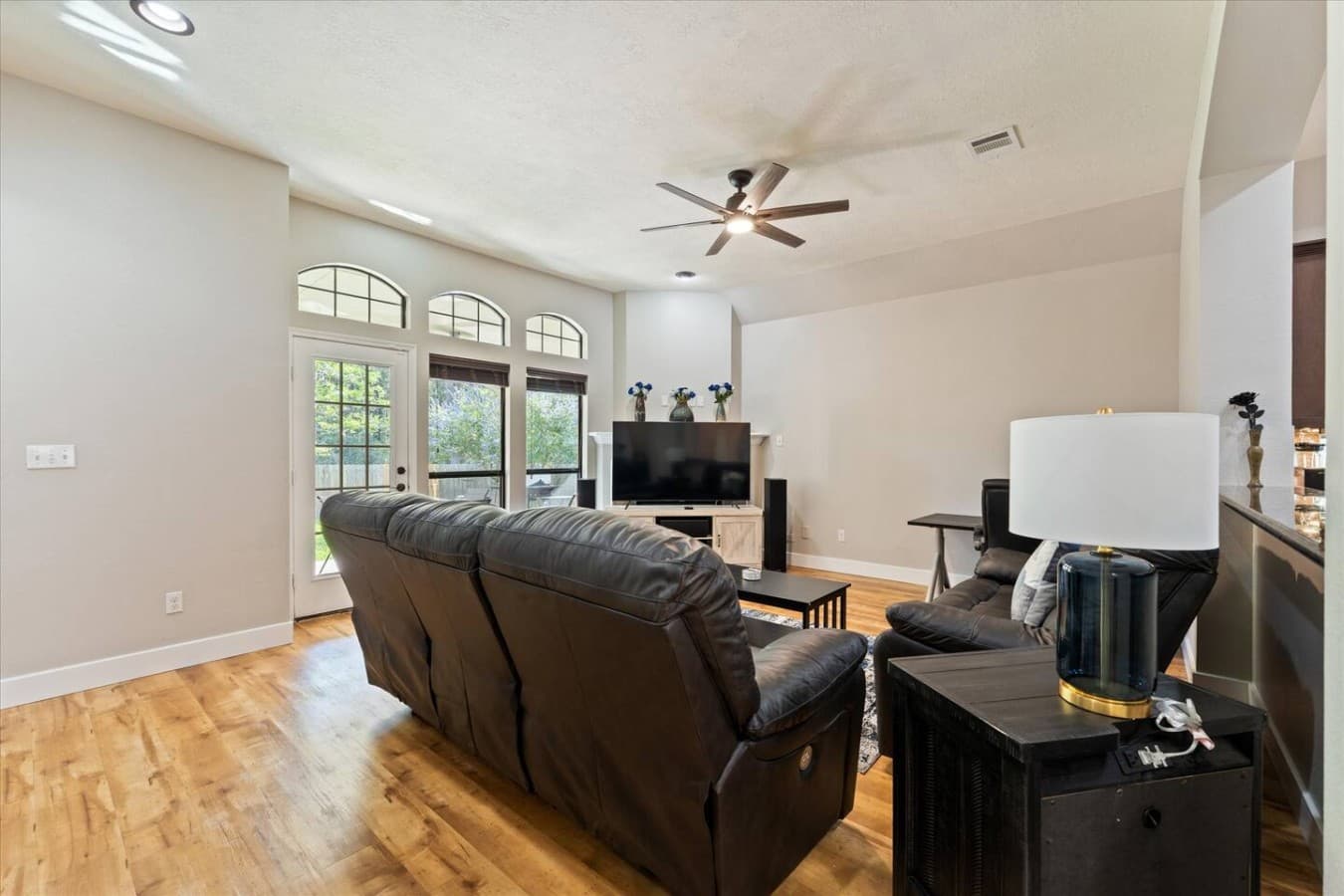 Bright and open living room with comfortable leather seating and natural light throughout.
