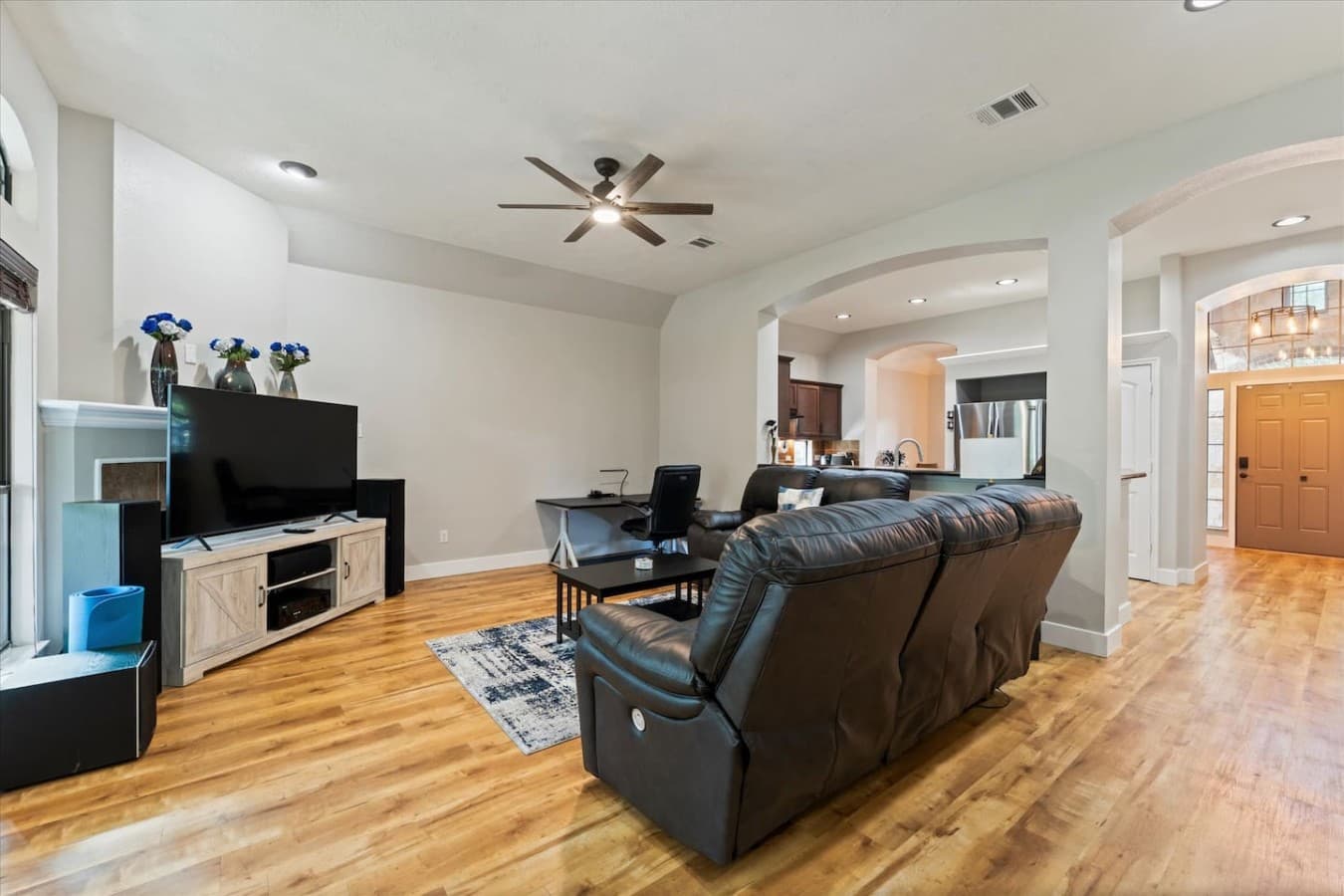 Spacious gathering space with vaulted ceilings and an open layout connecting the living area and kitchen.