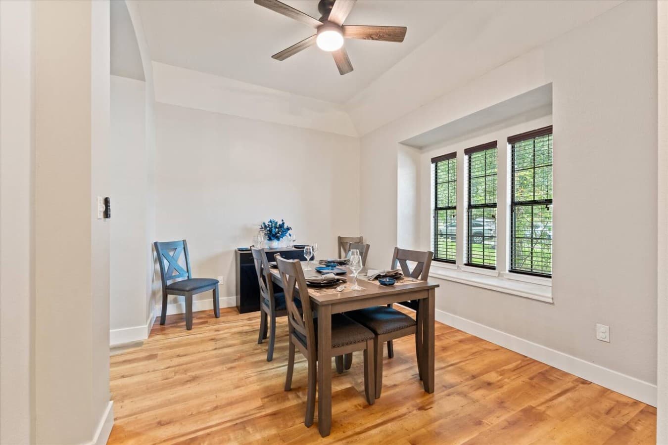 Bright dining area with seating for shared meals and large windows overlooking the property.