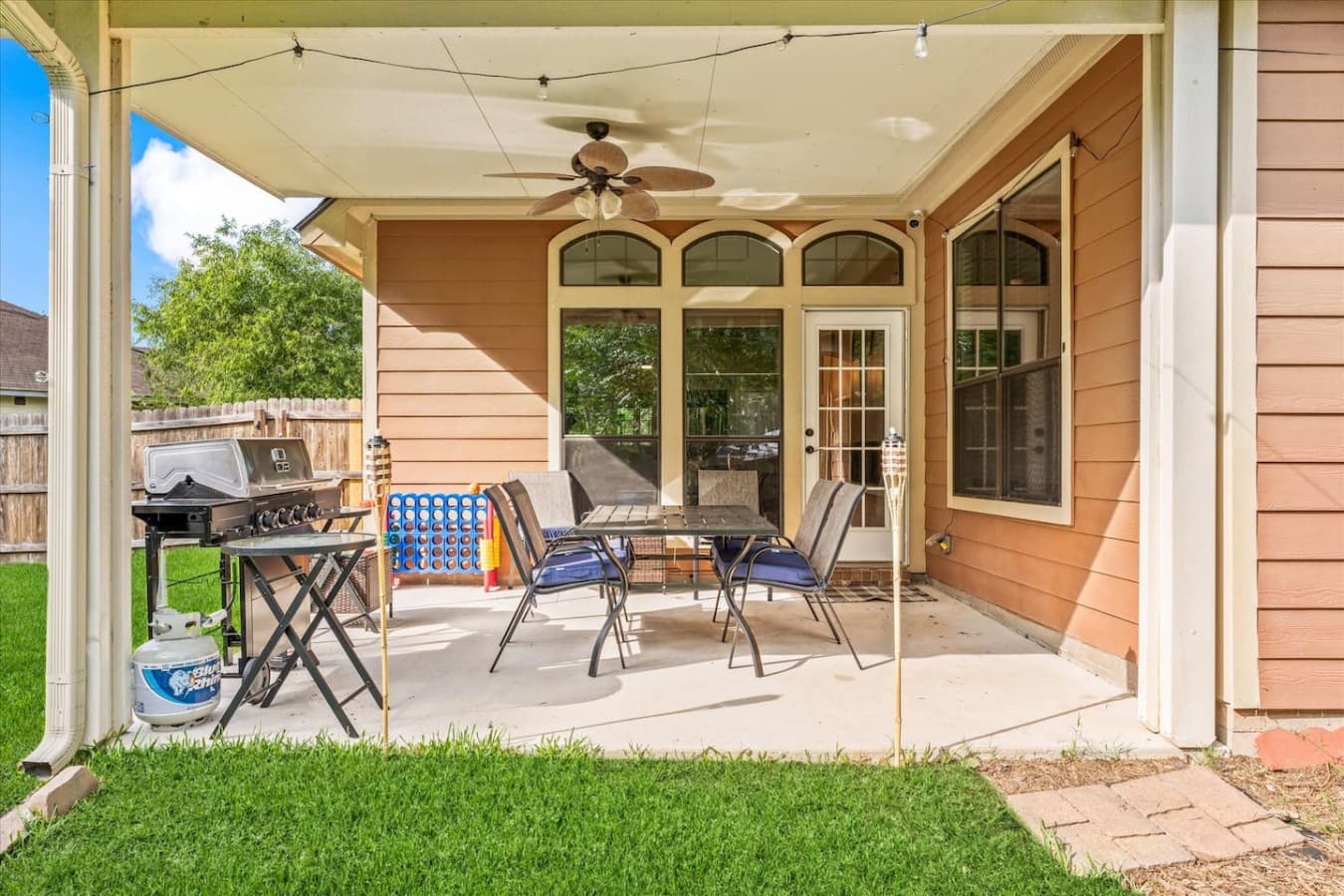 Covered backyard patio with outdoor dining space perfect for morning coffee or evening meals.