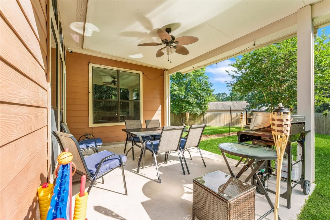 Spacious covered patio with comfortable seating and peaceful backyard views.