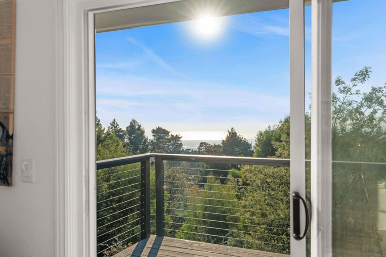 Balcony access with a beautiful view of the surrounding greenery and open sky.