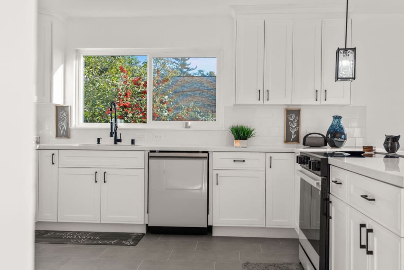 Clean and modern kitchen view with stainless steel appliances and a peaceful window outlook.