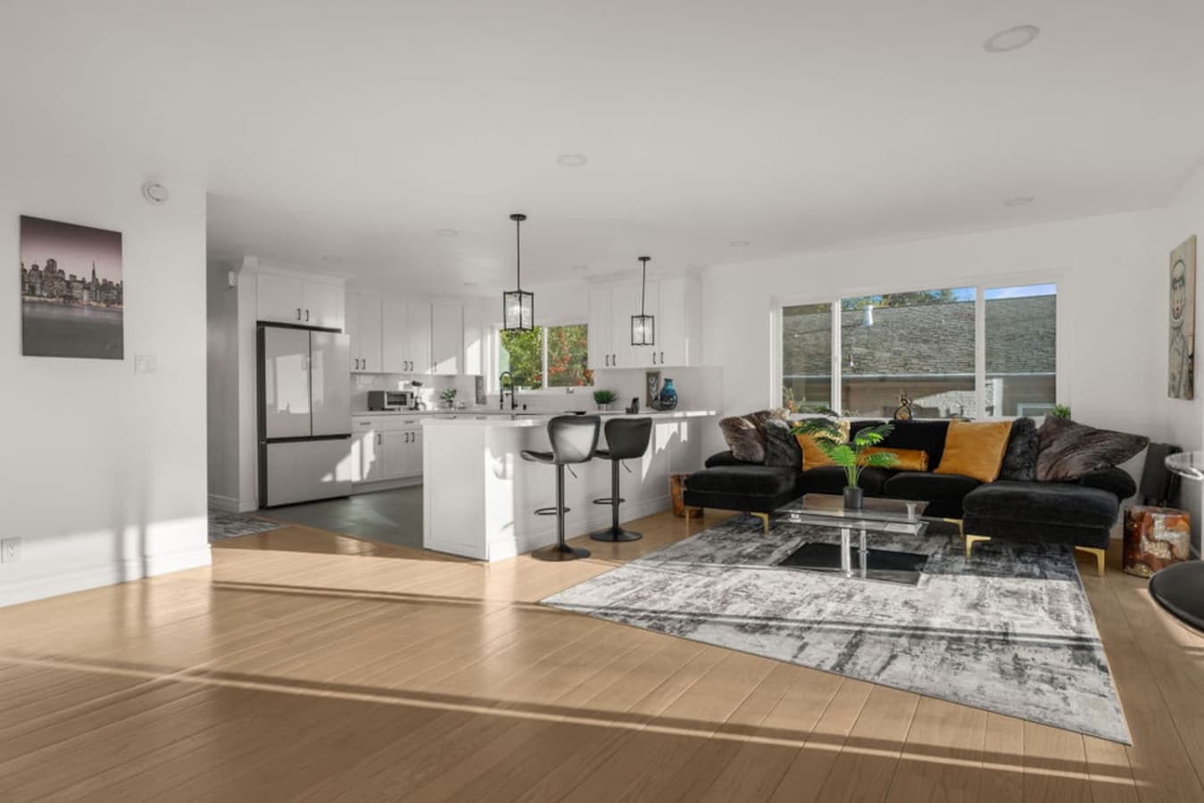 Spacious open-concept living area with comfortable seating and a bright kitchen nearby.