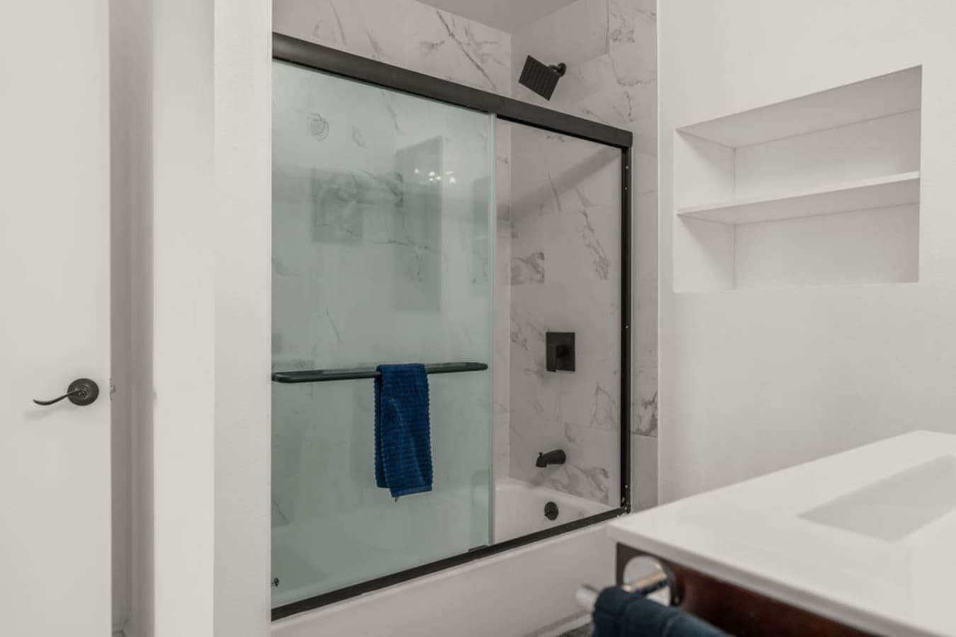 Bright shower area with sleek finishes and a glass enclosure.
