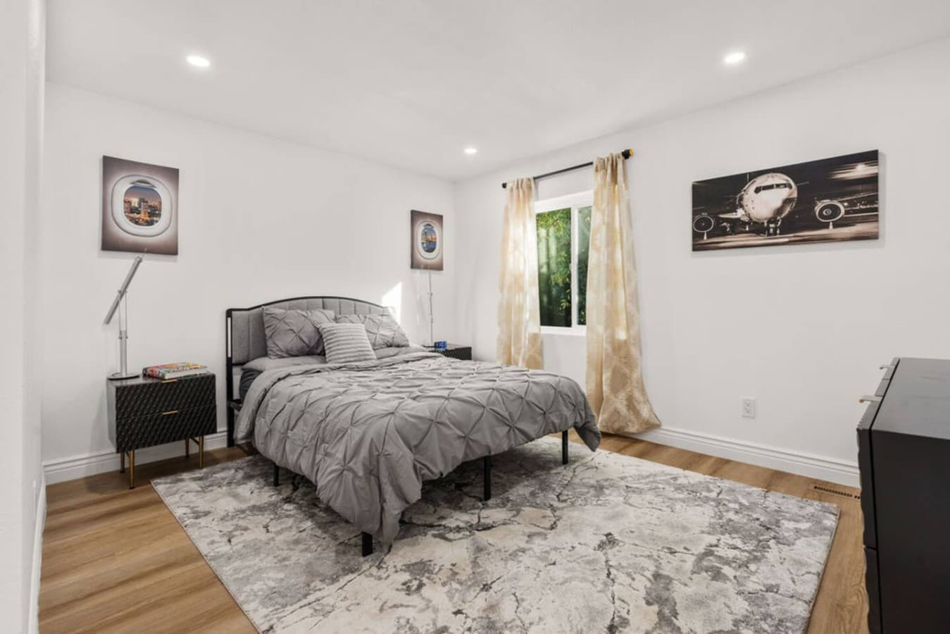 Spacious bedroom with a soft area rug and comfortable bedding creating a relaxing atmosphere.