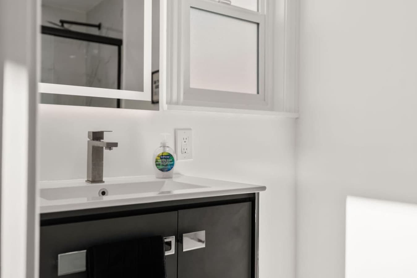 Clean bathroom vanity with modern fixtures and a bright polished finish.