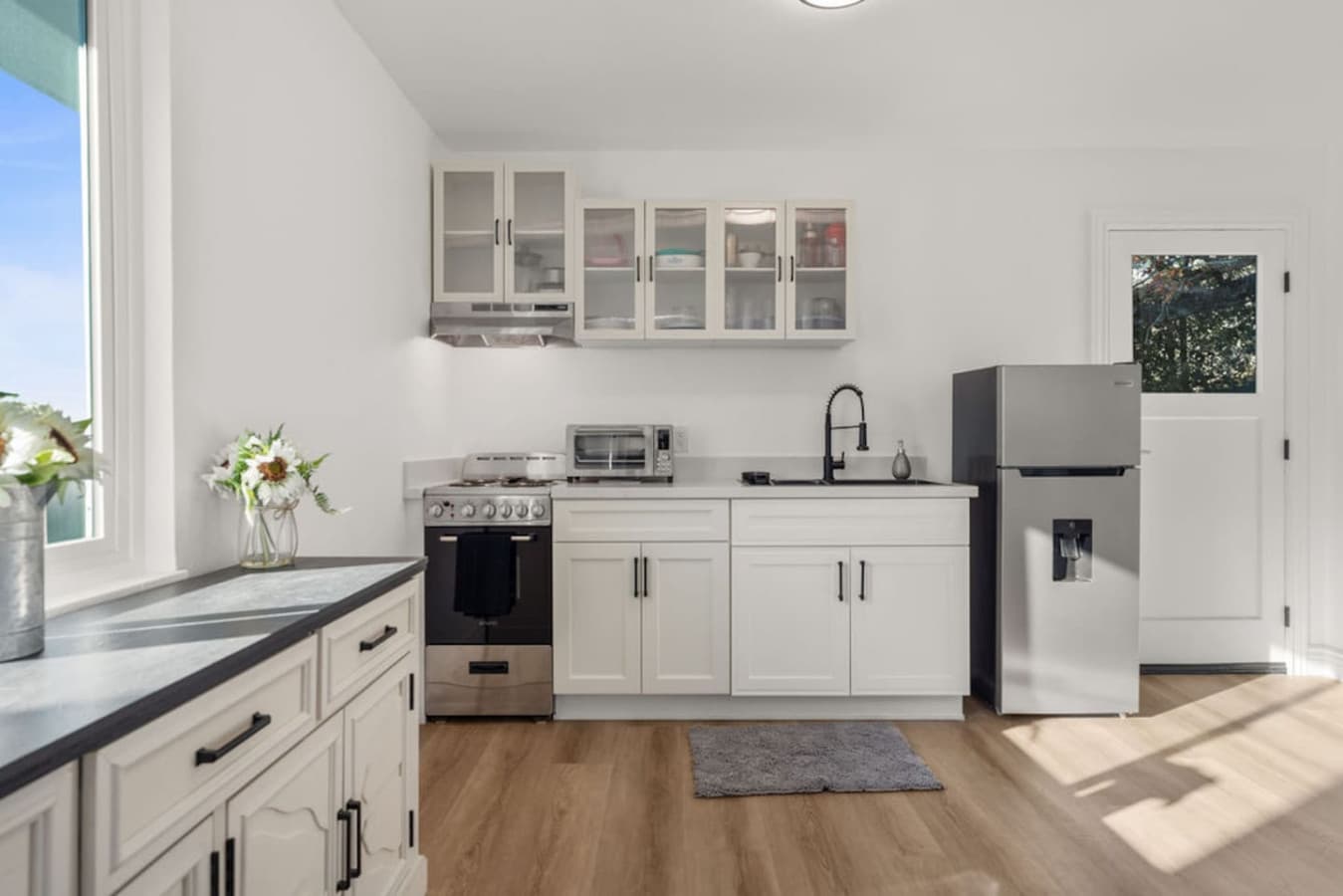 The Private In Law Suite kitchen offers a clean and efficient layout with modern appliances and fresh white cabinetry.