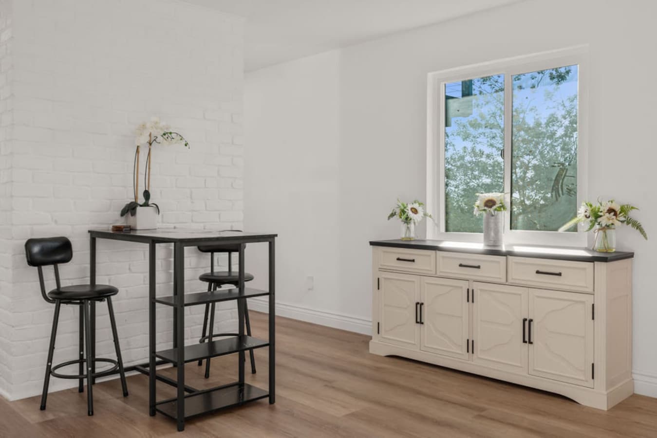 Cozy corner of the Private In Law Suite with a small dining setup and a window bringing in natural light.