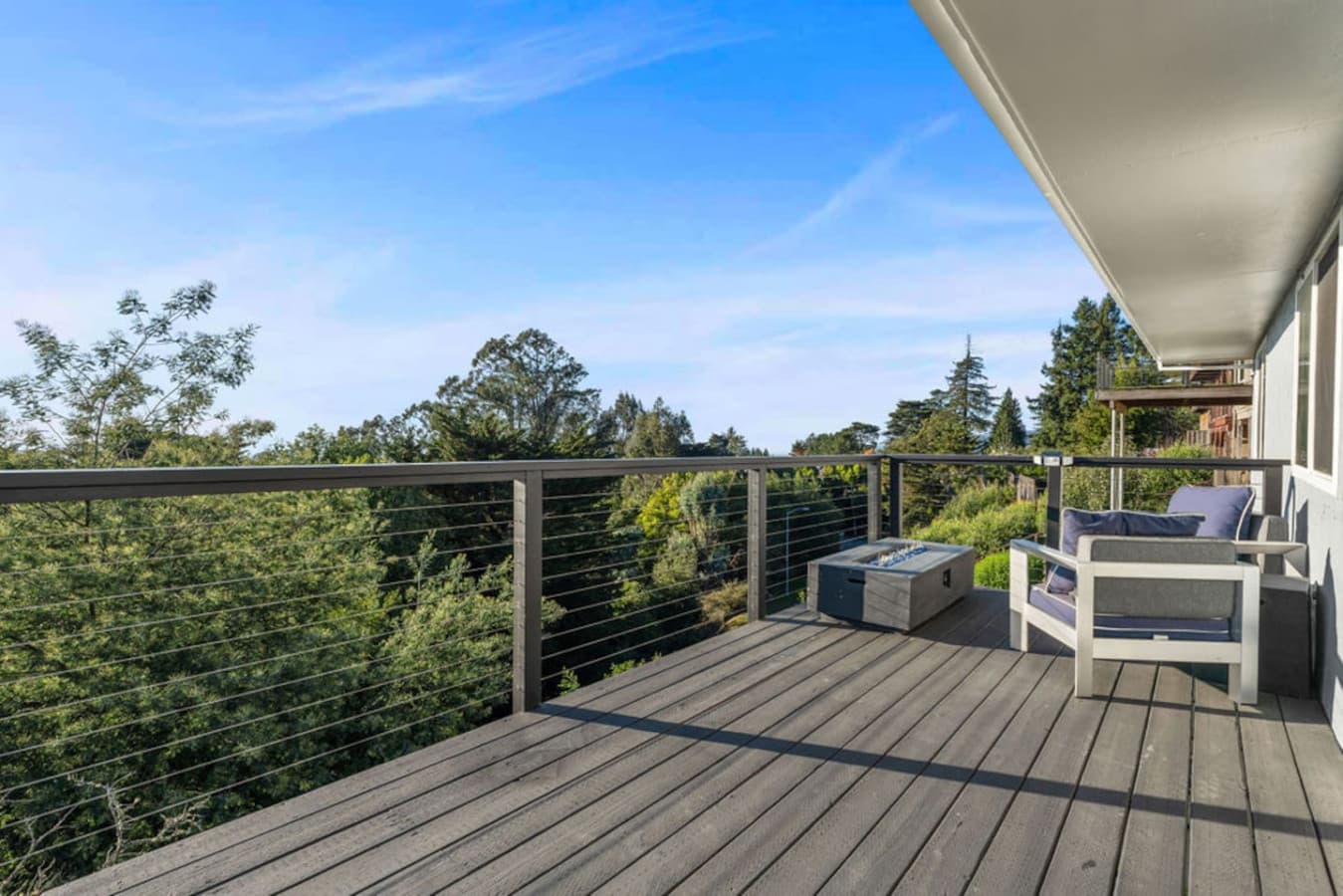 Open deck with comfortable seating and sweeping tree lined views.