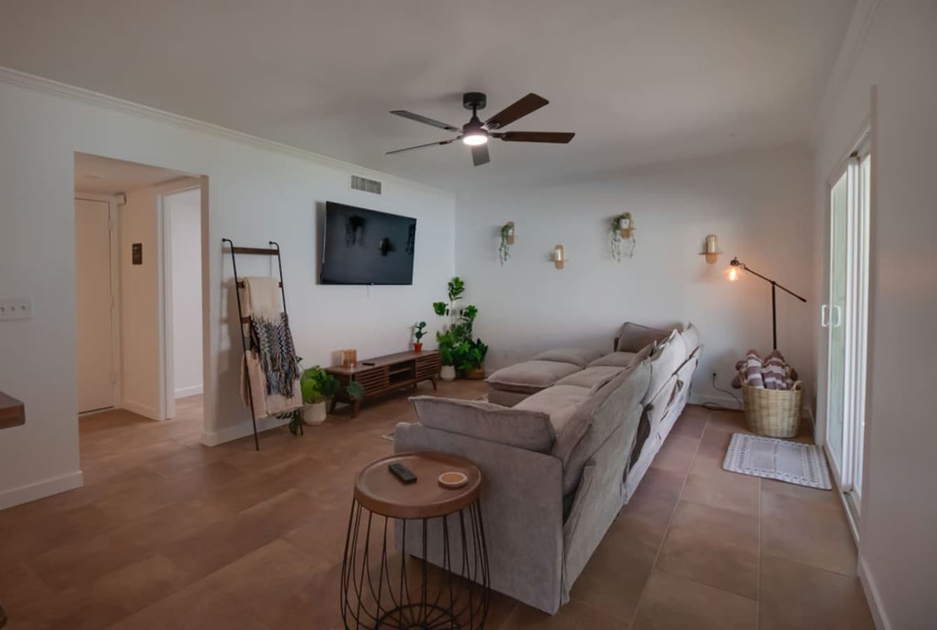 Comfortable living room with sectional seating and mounted TV.