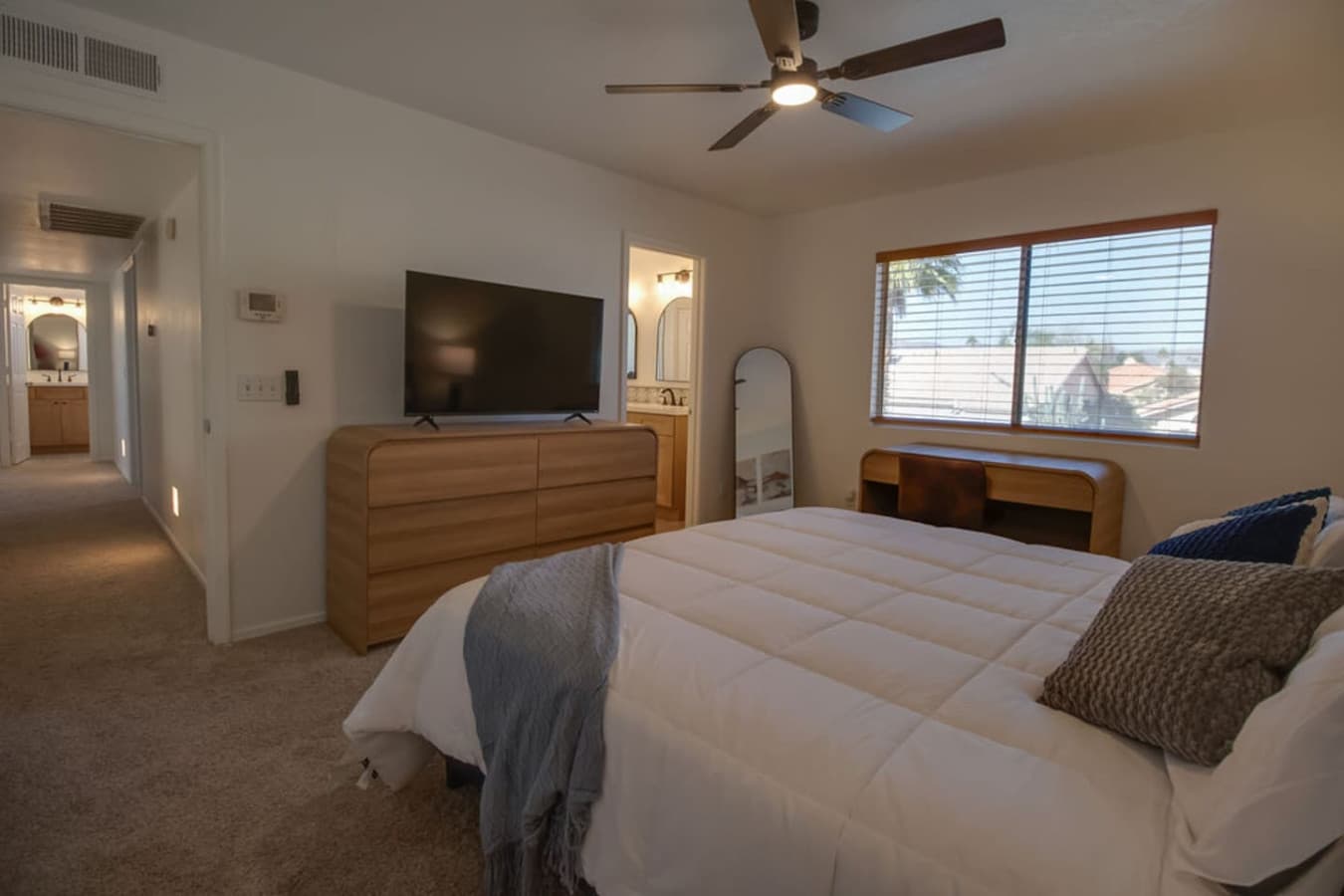 Relaxing bedroom with TV and warm natural light.