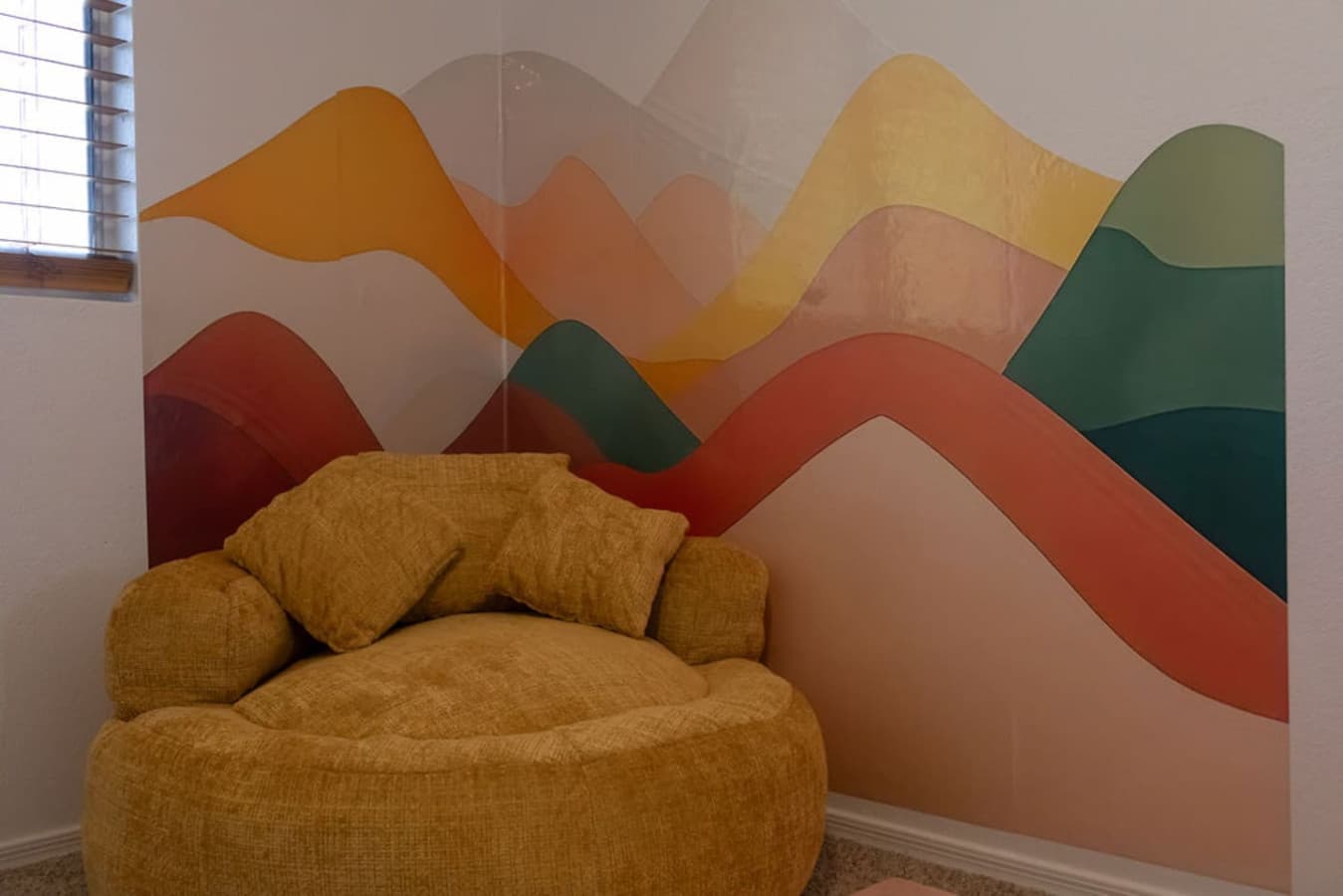 Cozy reading nook with plush chair and painted mural backdrop.