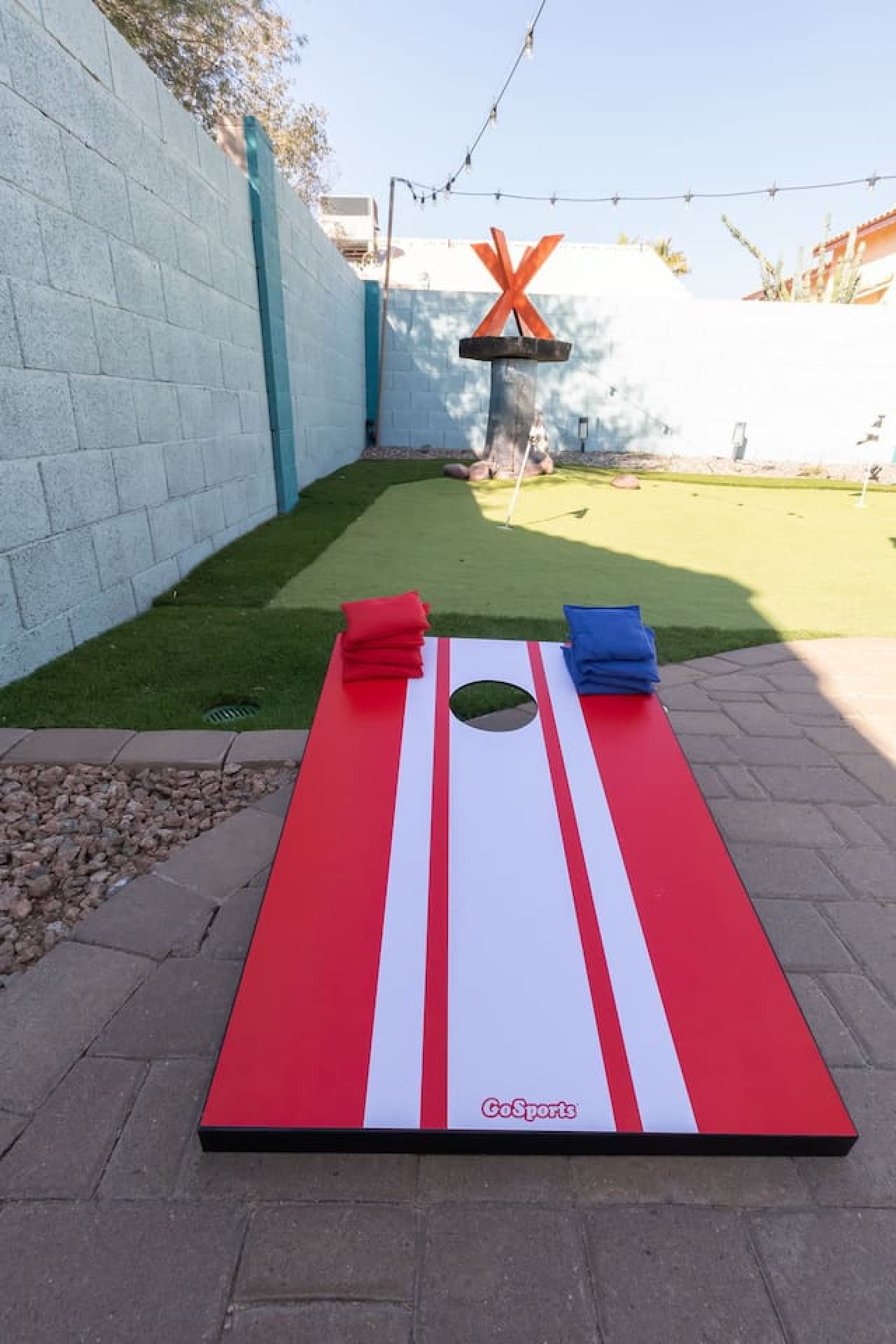 Backyard game space featuring cornhole and open play area.