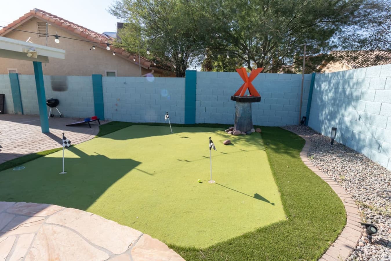 Backyard putting green with multiple holes for casual practice.