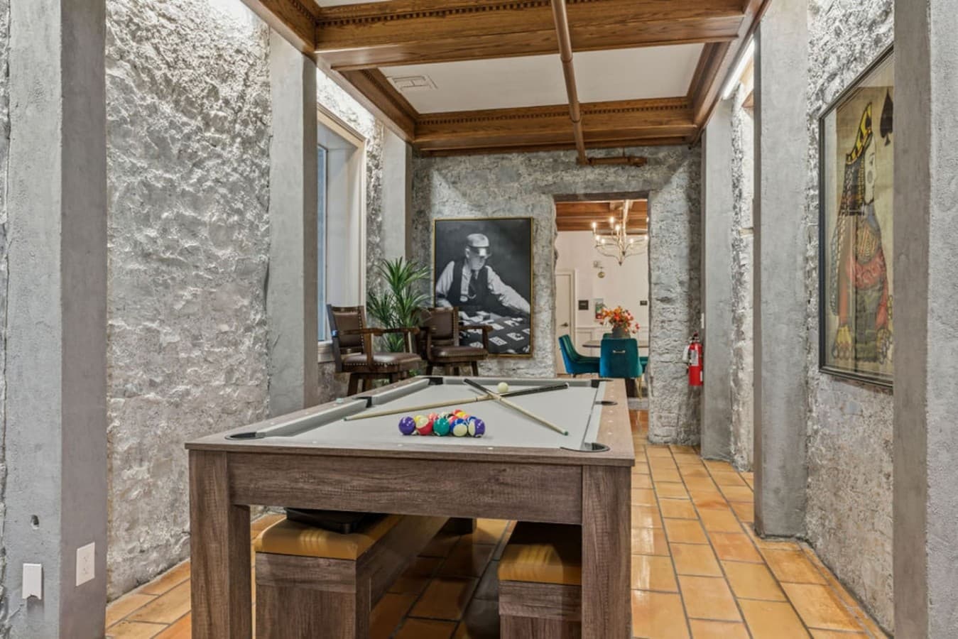A charming shared game room with a pool table and eclectic art pieces providing an inviting setting for friendly competition.