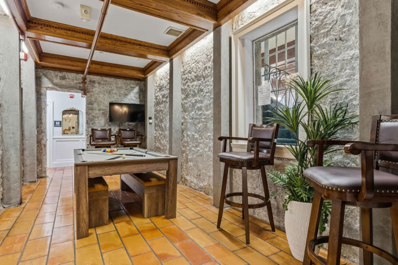 A cozy shared game area with additional seating and warm natural textures creating a relaxed spot to unwind.