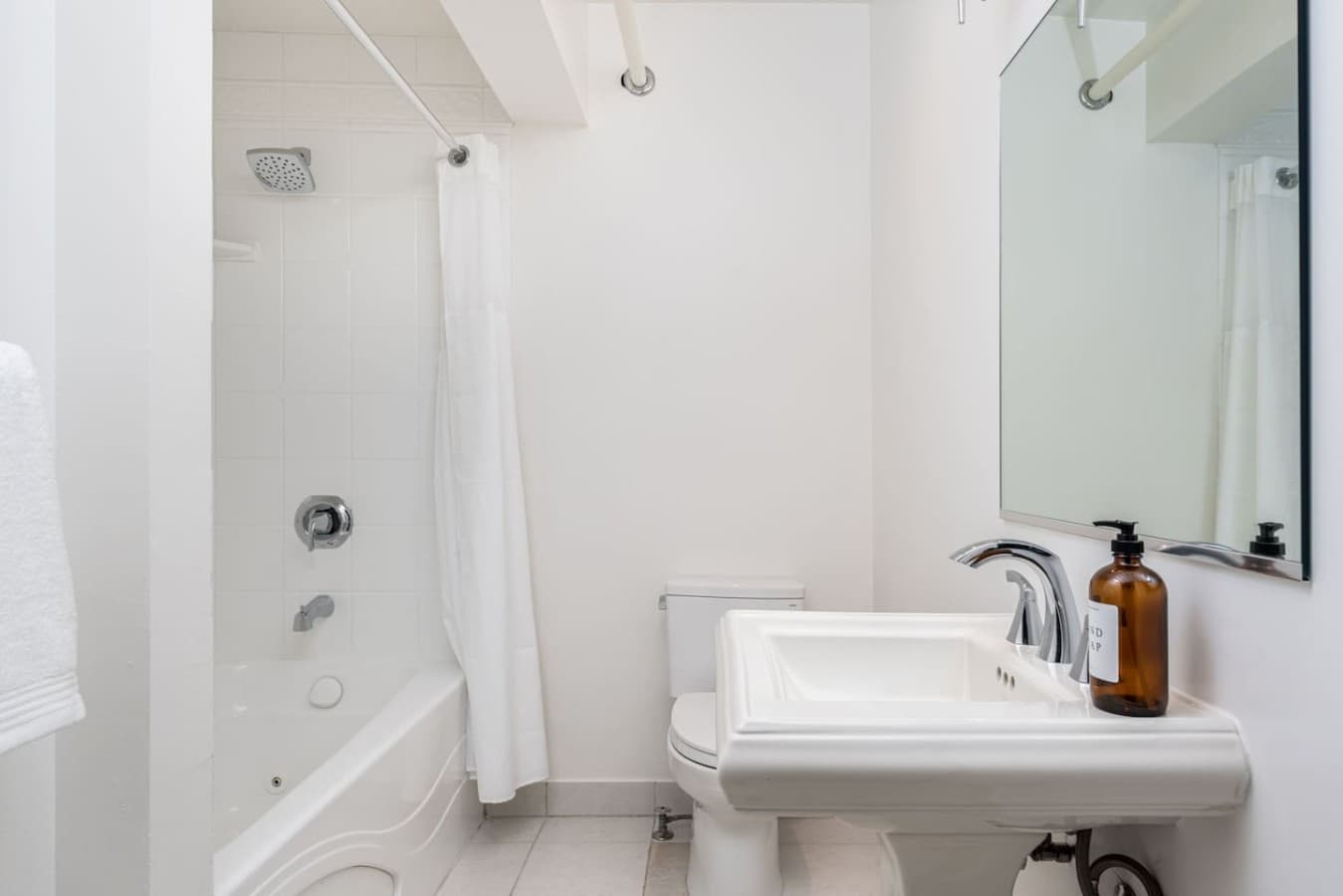 This is the private bathroom inside the room you will be renting featuring a clean shower and tub combination with simple, bright finishes.