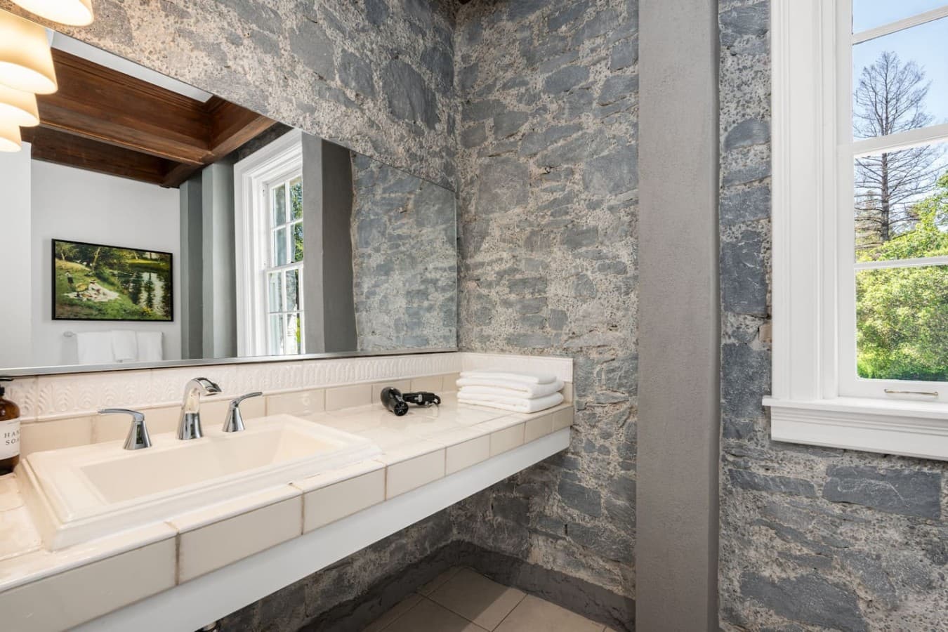 This is the private bathroom inside the room you will be renting featuring stone-accented walls and a spacious vanity area.