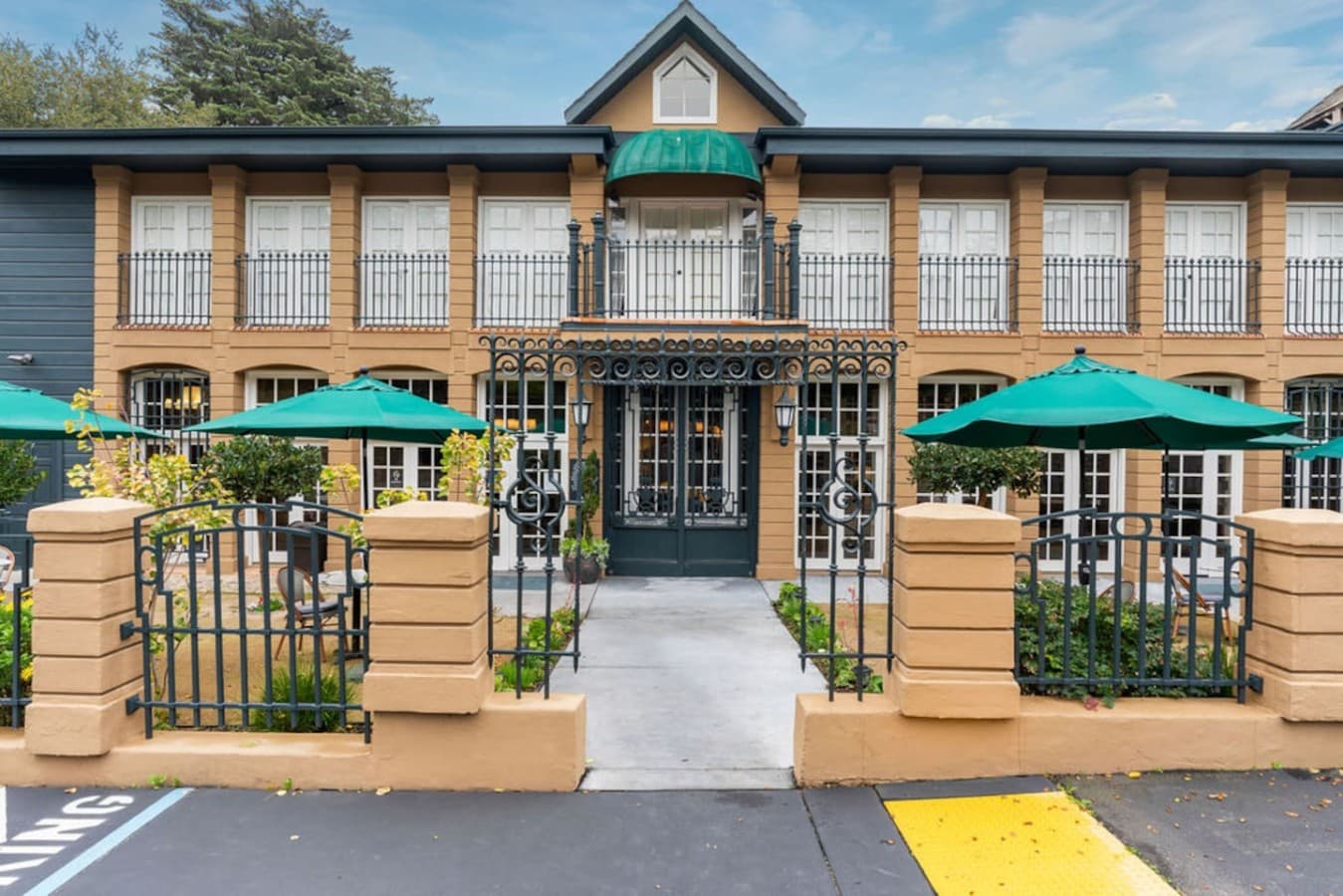 An elegant facade featuring tall windows, classic architecture, and thoughtfully maintained gardens.