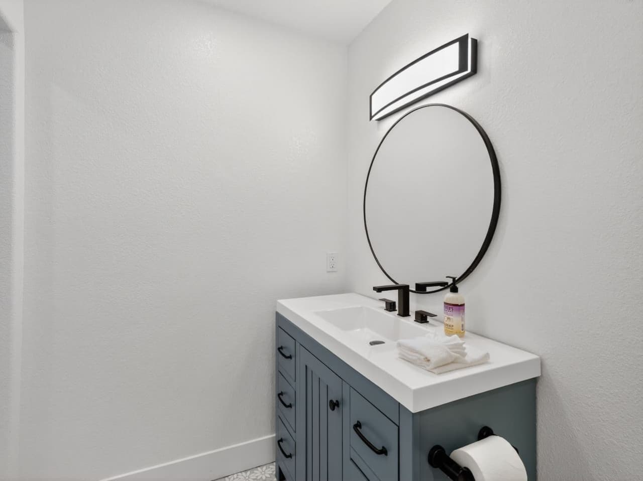 Convenient half bathroom with modern vanity and mirror.