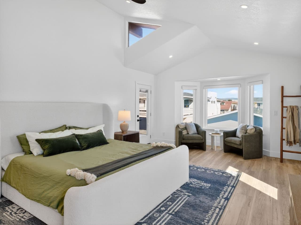 Primary bedroom with seating area and beautiful natural light.