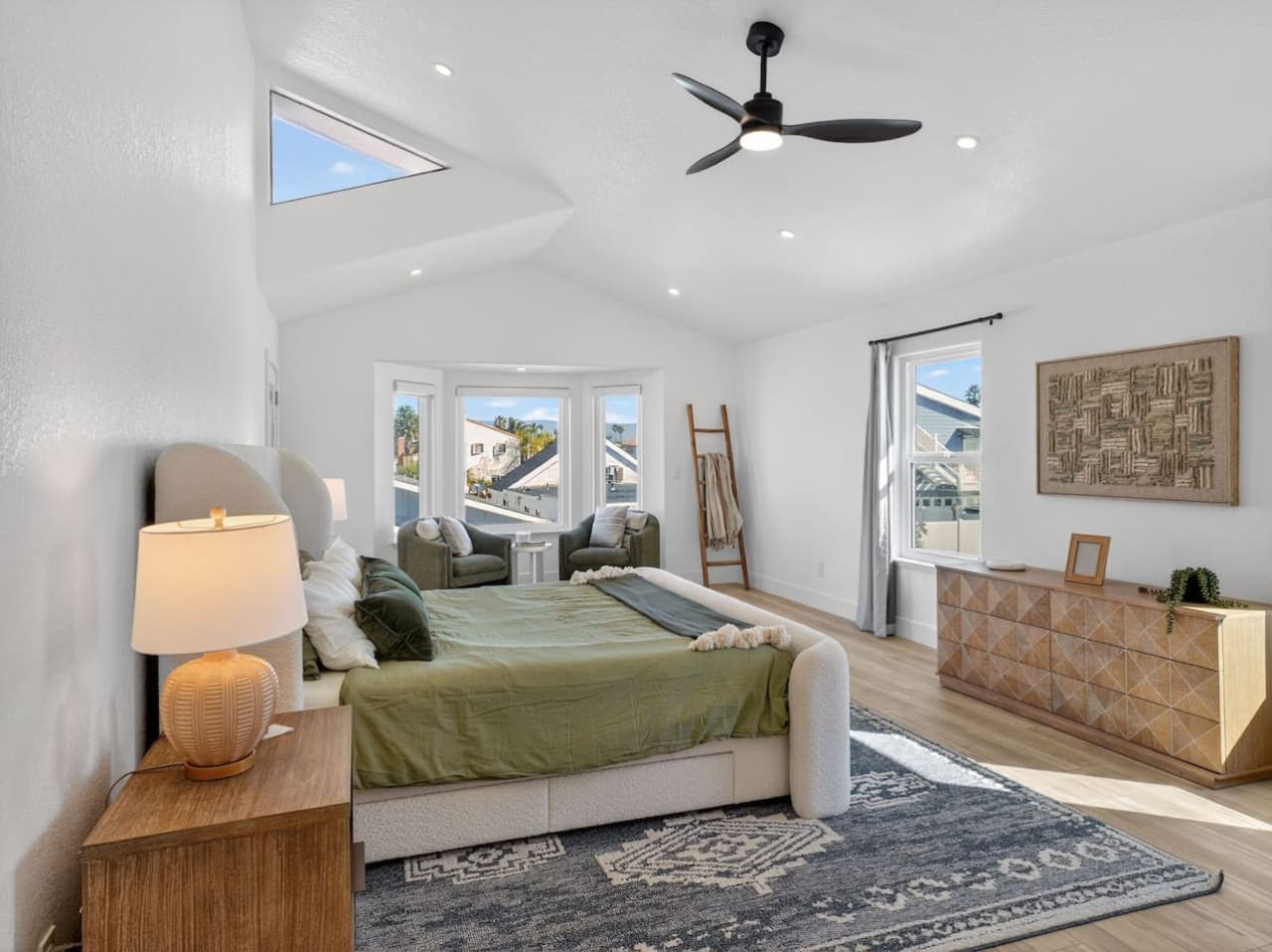 Bright primary suite with vaulted ceilings and cozy lounge space.