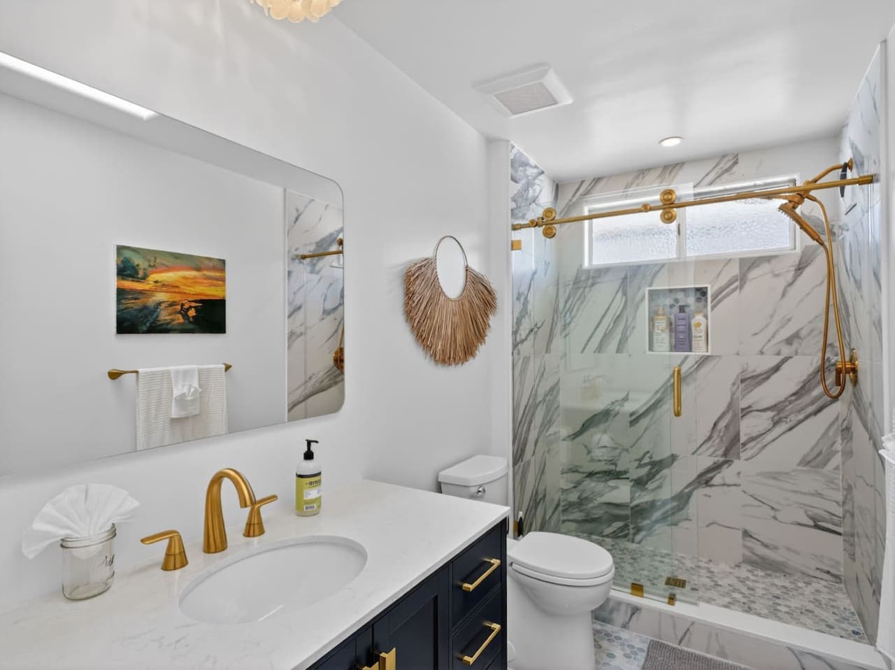 Spa inspired bathroom with marble shower and gold fixtures.