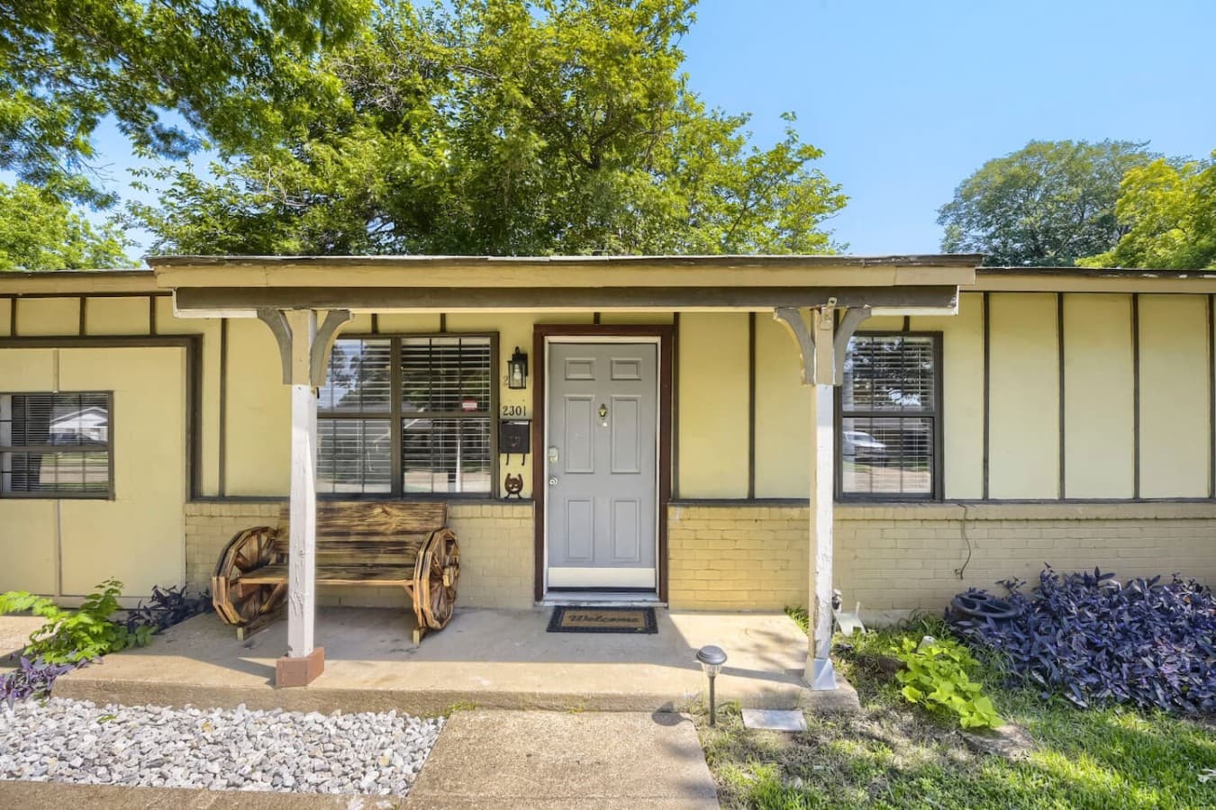 Charming front entrance with welcoming covered porch and seating area.
