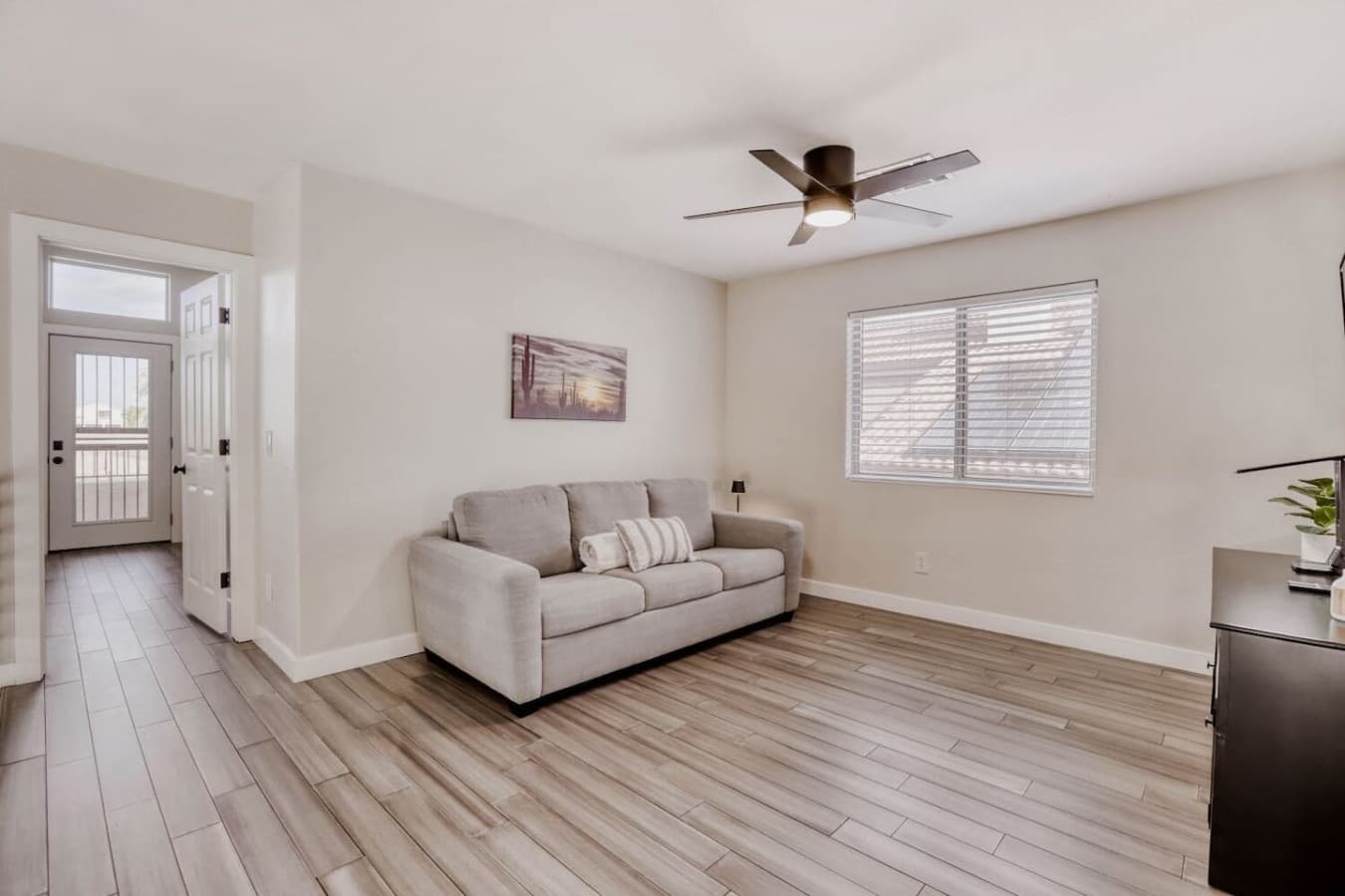 Secondary living area with plush seating and ceiling fan for added comfort.