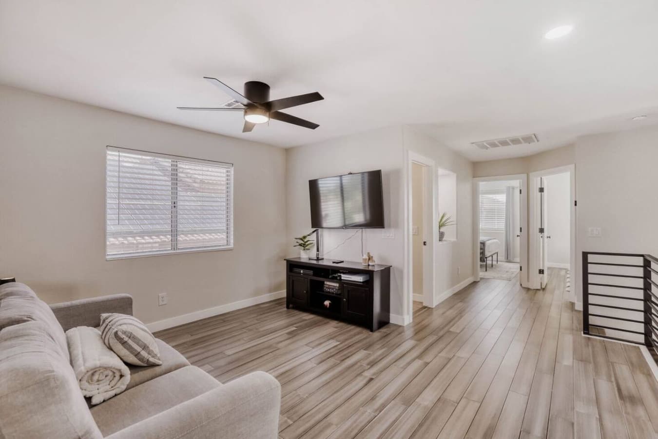 Bright living space with media console and easy access to surrounding rooms.