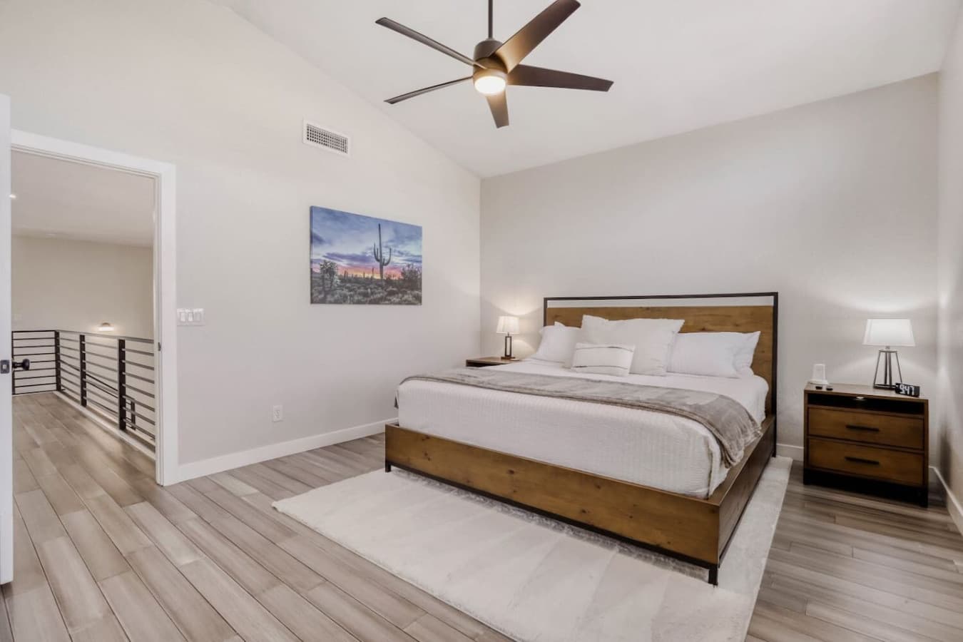 Serene bedroom retreat with a plush bed, ceiling fan, and calming neutral tones.