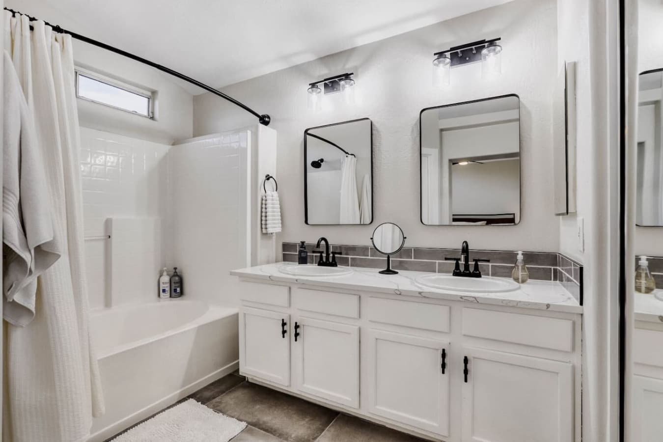 Spacious bathroom featuring dual vanities and a bright clean design.