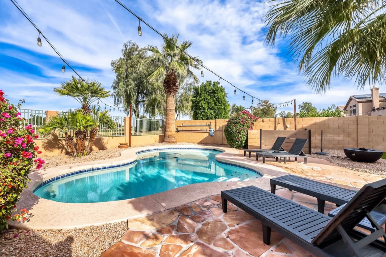 Sun drenched pool area with loungers and peaceful desert surroundings.