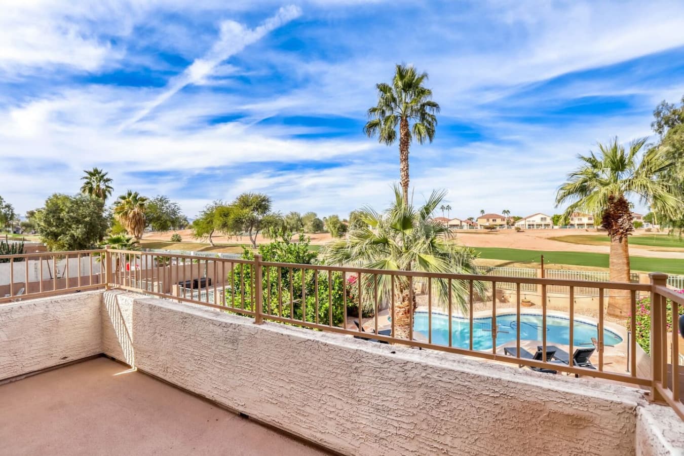 Elevated balcony with views overlooking the pool and nearby greenery.