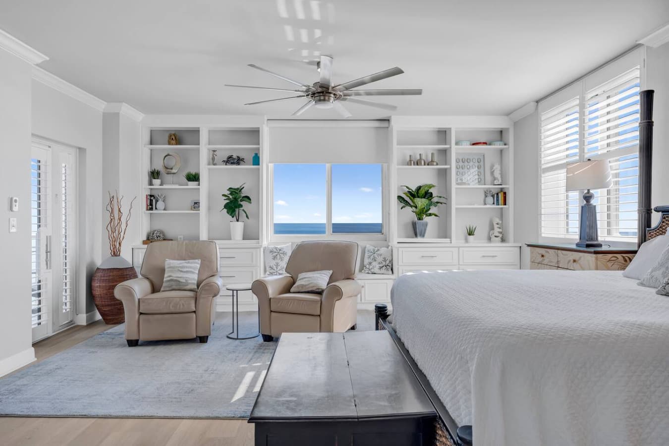 Comfortable bedroom with built in shelving and peaceful coastal ambiance.