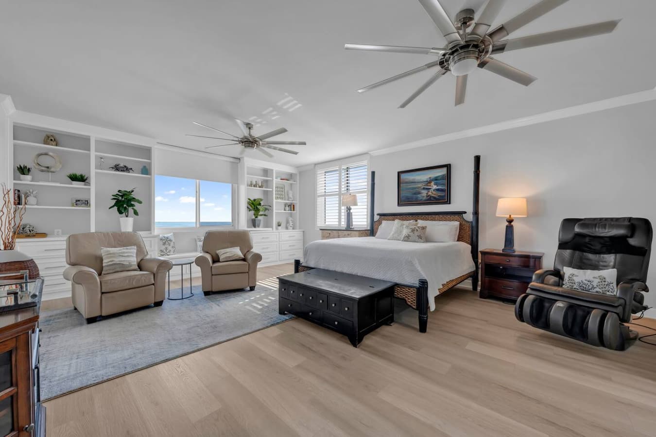 Spacious primary bedroom with comfortable seating area and natural light.