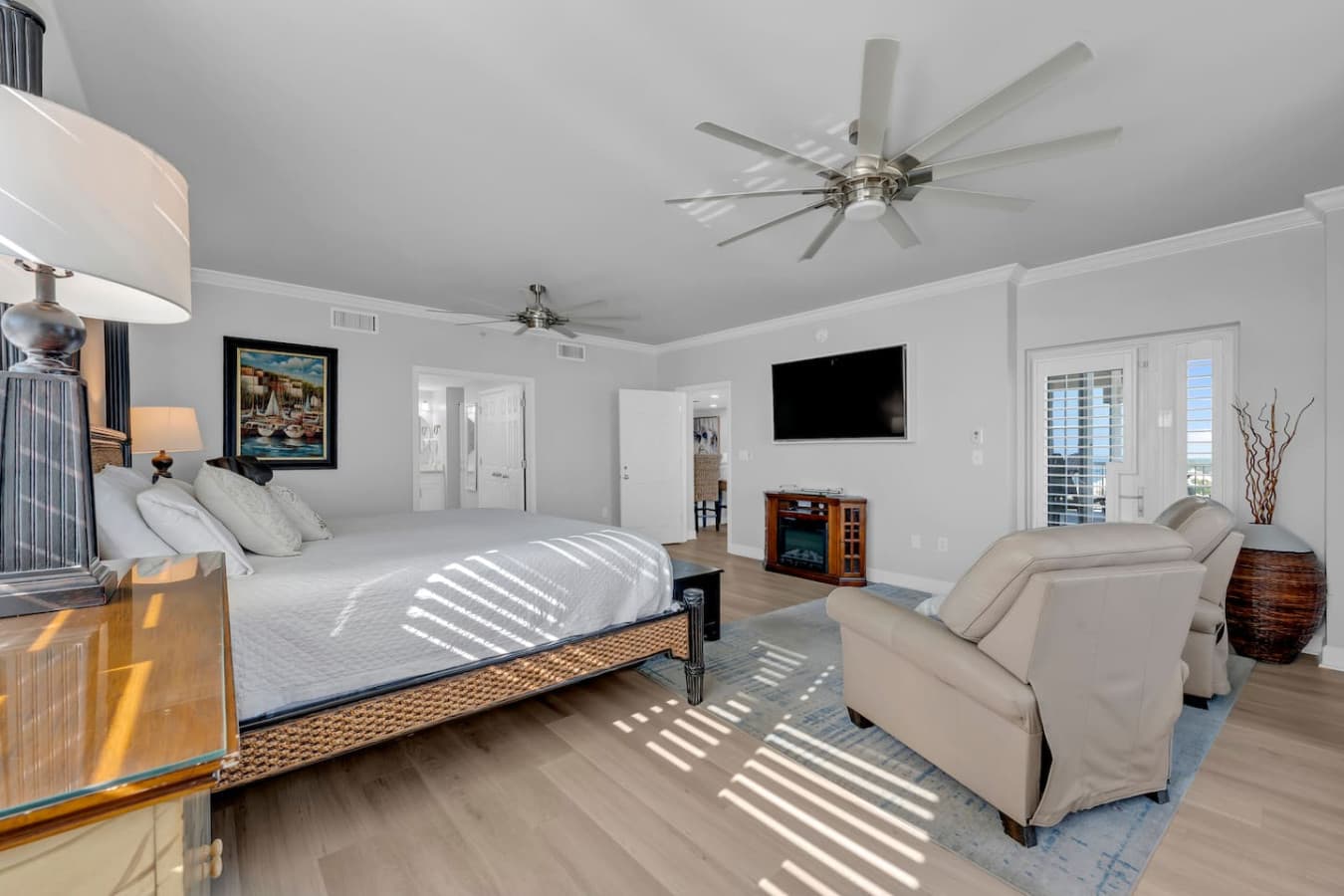 Large bedroom featuring plush seating and mounted TV.