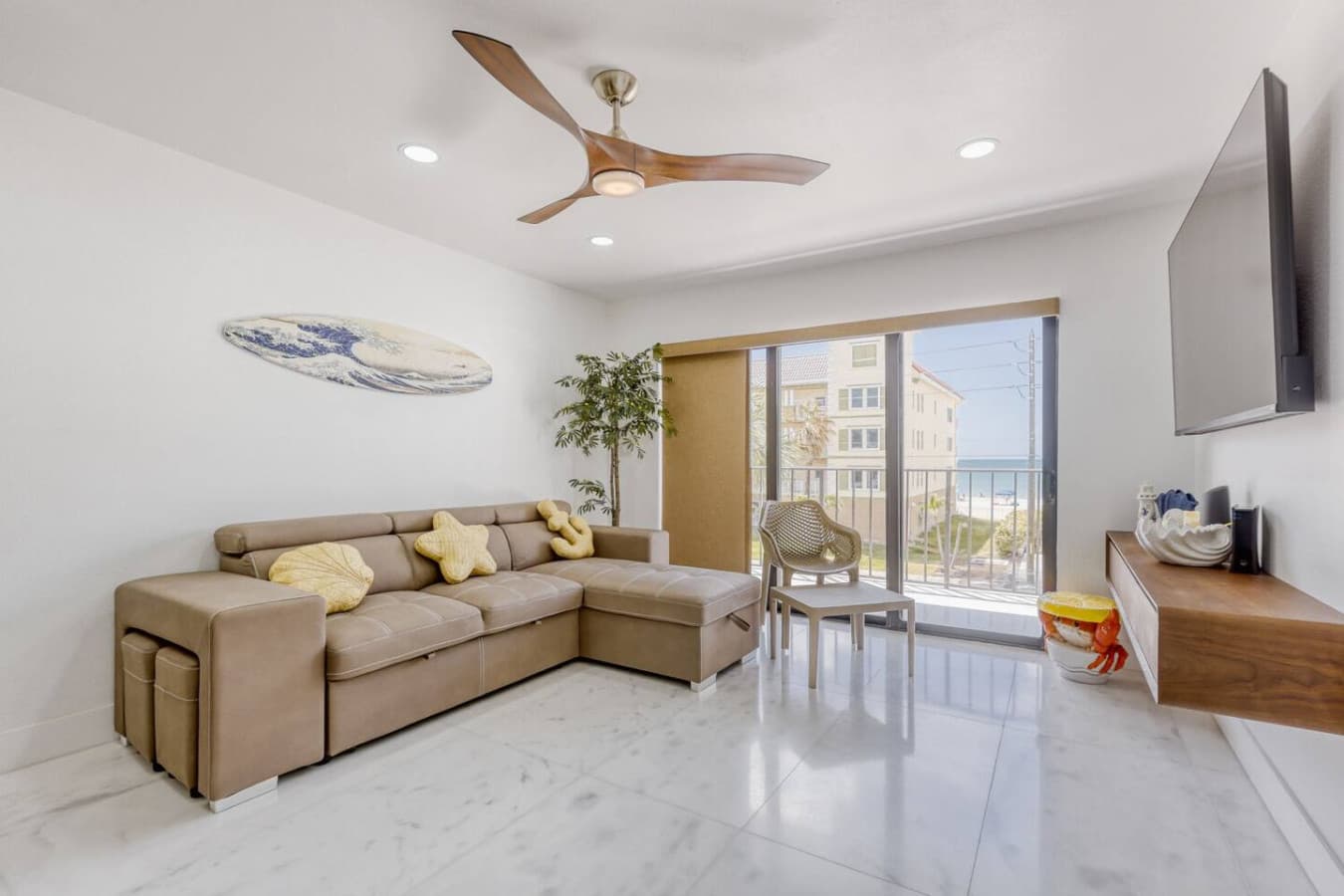 Bright living room with sectional seating and balcony access.