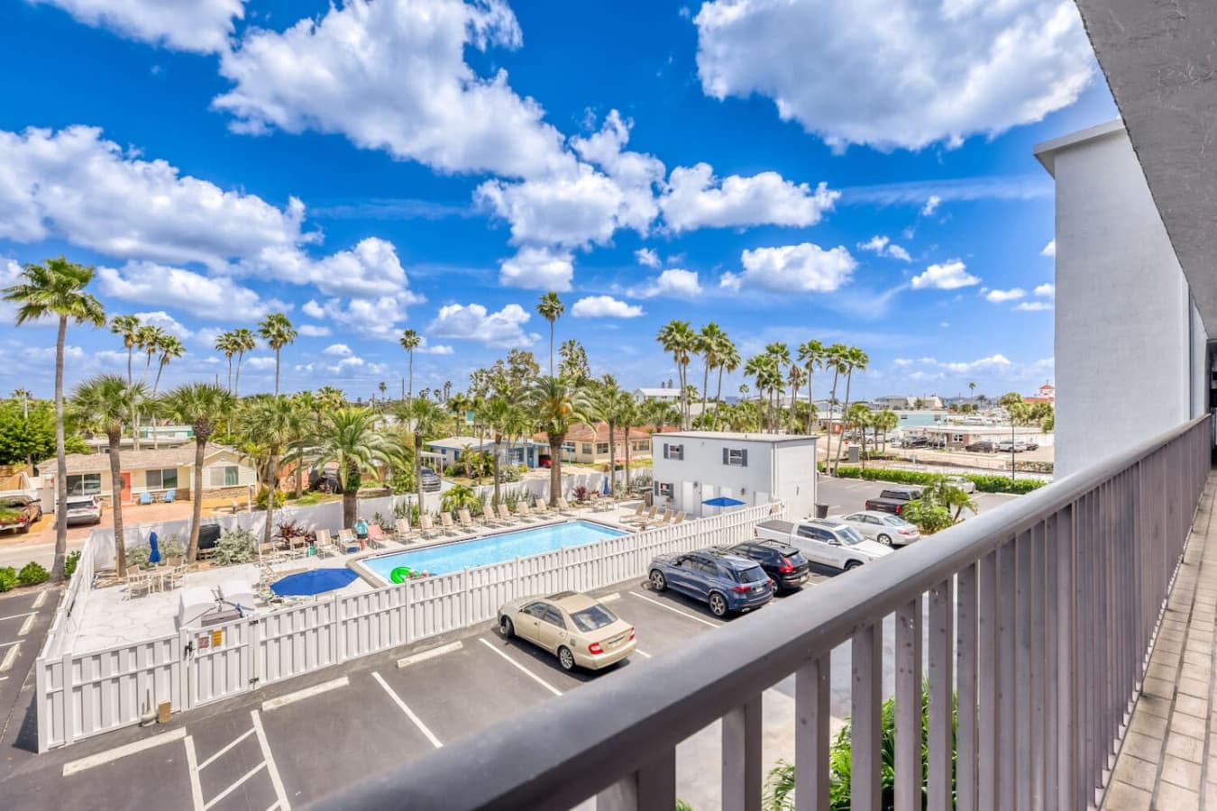 Elevated balcony with pool and coastal surroundings.