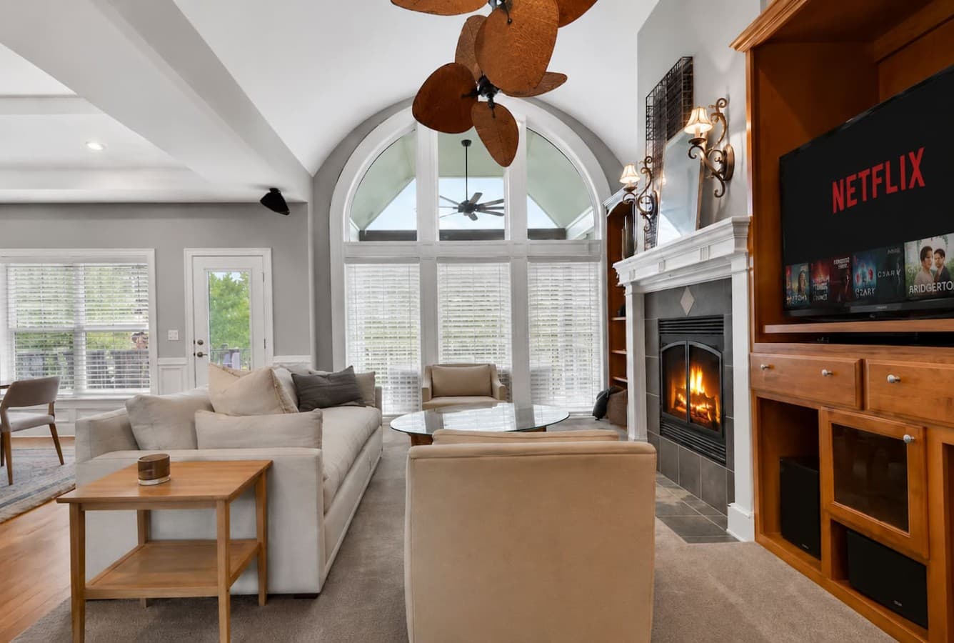 Cozy fireplace seating area with oversized windows and a warm inviting atmosphere.