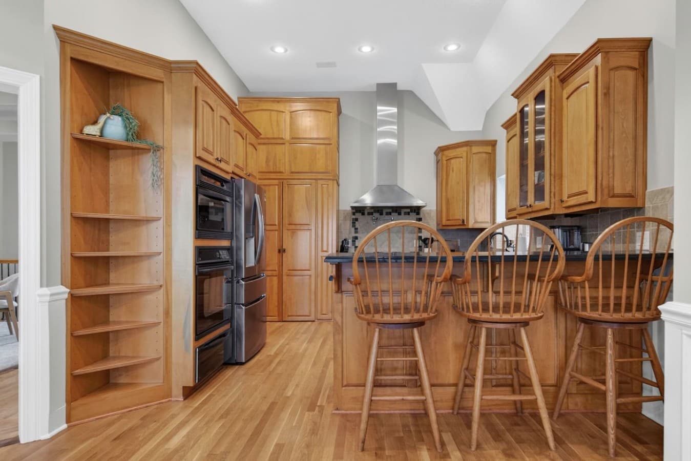 Bright gourmet kitchen with generous cabinetry, built in appliances, and inviting breakfast bar seating.
