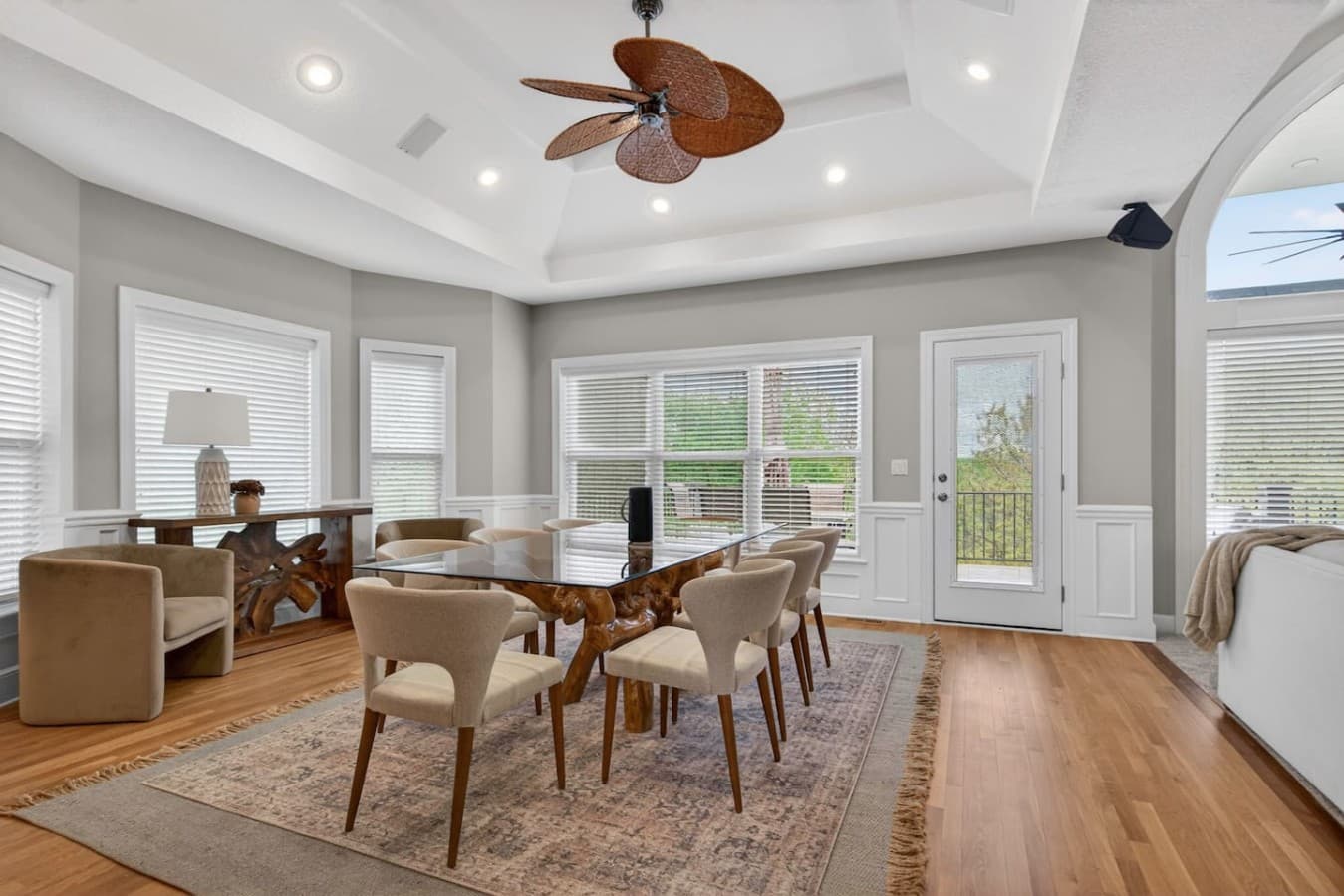 Elegant dining area with large windows, tray ceilings, and direct access to the outdoor deck.