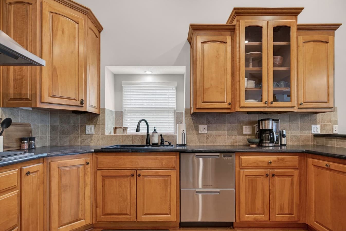 Fully equipped kitchen with custom wood cabinetry, stainless steel appliances, and plenty of prep space.