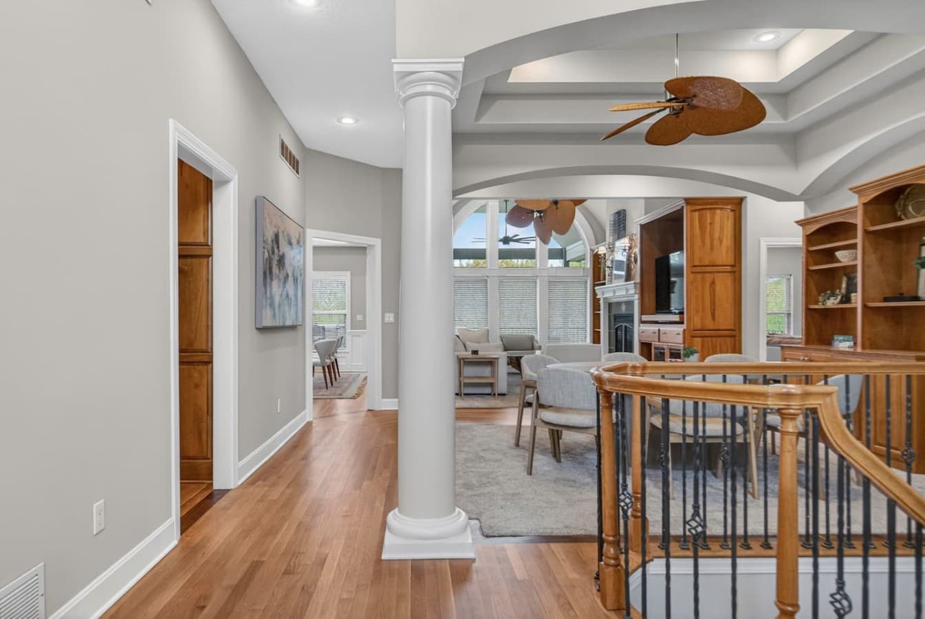 Grand upper level walkway with soaring ceilings, elegant columns, and open views into the main living area.