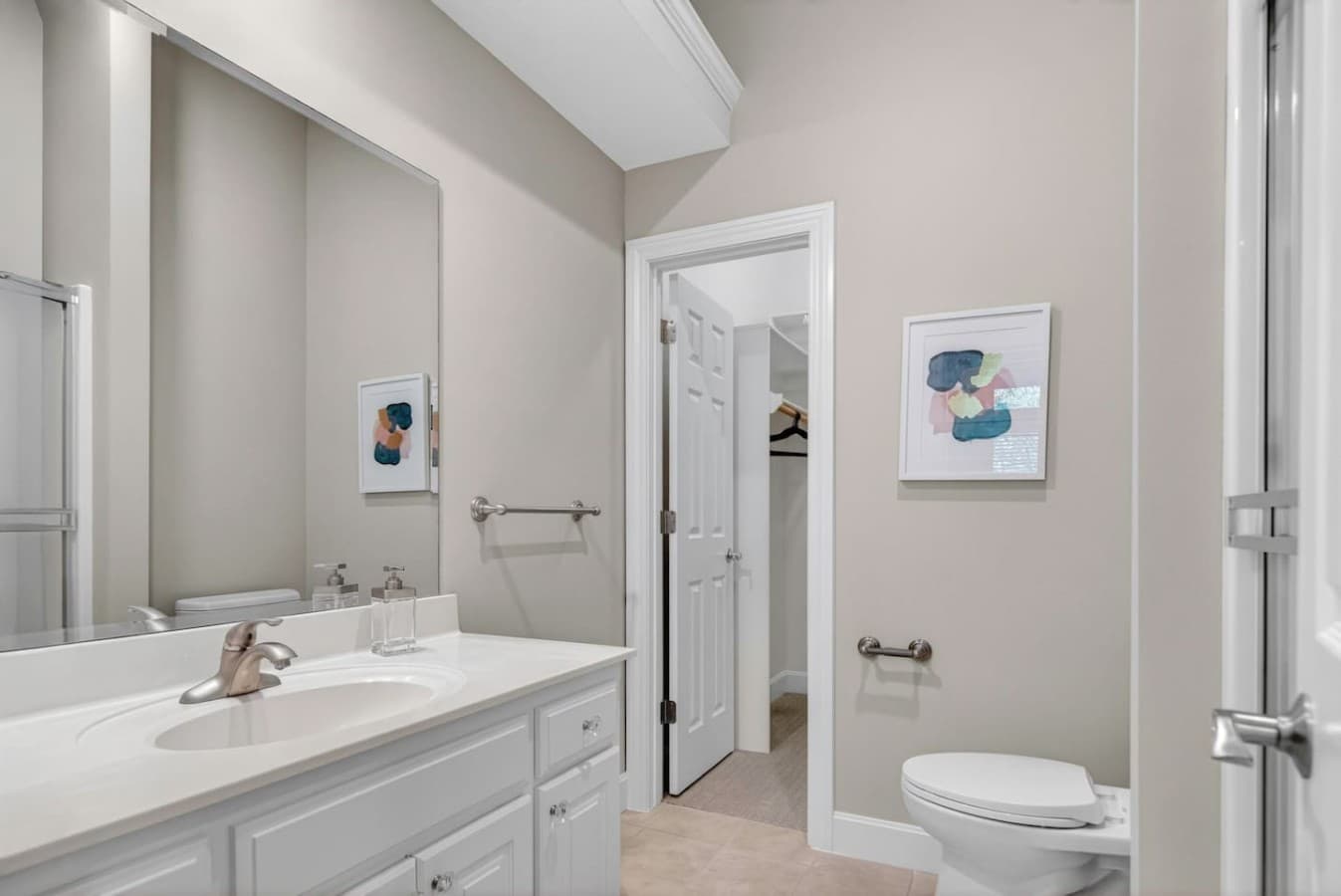 Bright and clean bathroom with modern finishes, ample counter space, and convenient access to the adjoining bedroom.